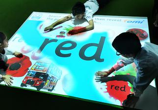 children on floor with omi's projection of red items