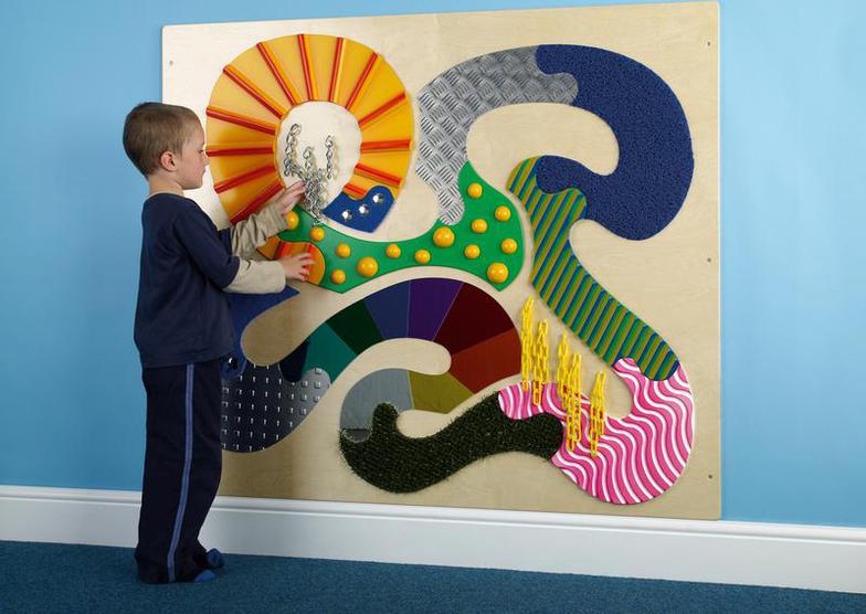 boy playing with tactile wall panel close-up