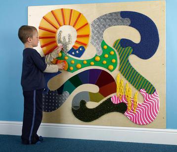 boy playing with tactile wall panel