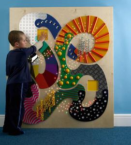 boy playing with tactile wall panel