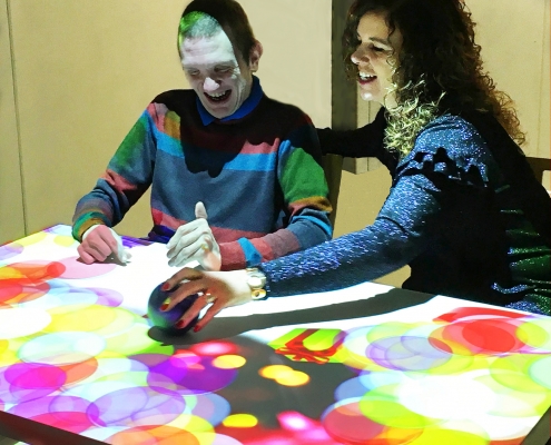 Special needs adult interacting with omi's table projection
